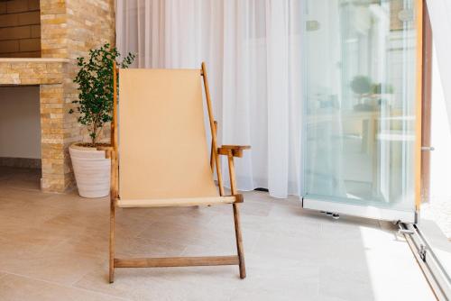 a wooden chair in a room with a window at City Apartment One in Mostar