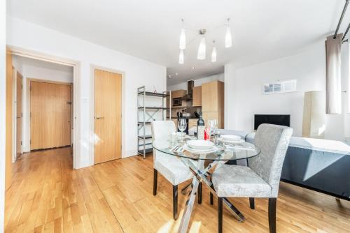 a dining room with a glass table and chairs at Pass the Keys - Modern and cosy flat in the hart of Central London in London