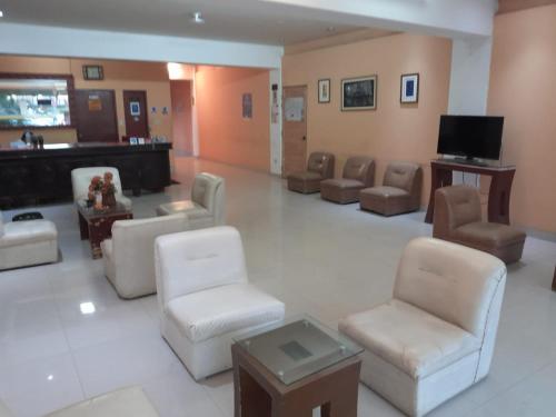 a waiting room with chairs chairs and a television at Hotel el sol in Chiclayo