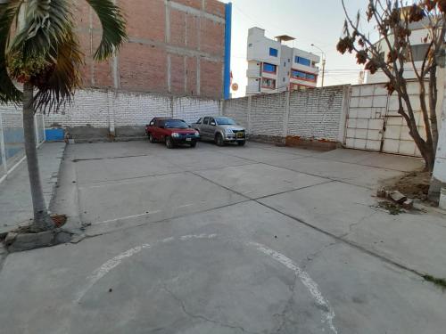 two cars parked in a parking lot next to a building at Hotel el sol in Chiclayo