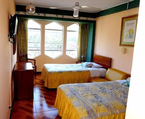 a hotel room with two beds and a window at Hotel el sol in Chiclayo