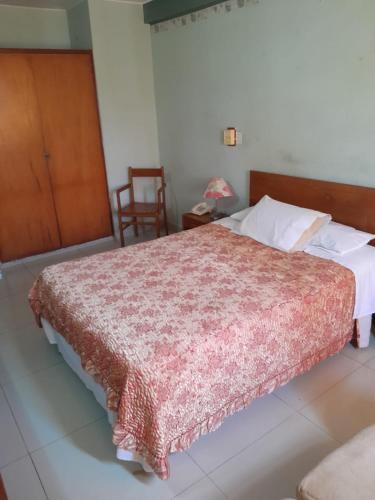 a bedroom with a bed with a red blanket on it at Hotel el sol in Chiclayo