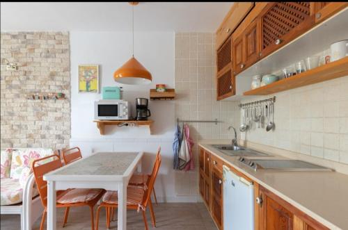 eine Küche mit einem Tisch, Stühlen und einem Waschbecken in der Unterkunft Apartamento Nire Lula en la misma playa in Cotillo