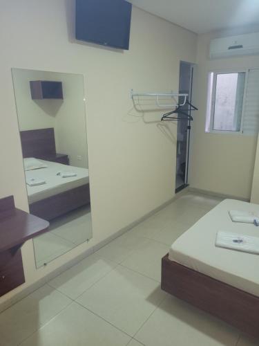 a room with two beds and a mirror at hotel royal brás in São Paulo