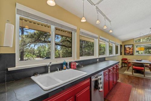 een keuken met een wastafel en ramen en een eetkamer bij Artsy Downtown Treehouse Perfect Flagstaff Location in Flagstaff