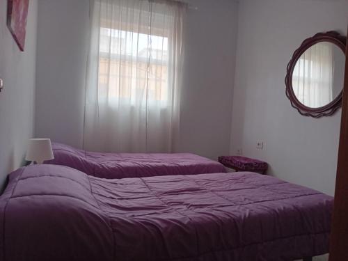a bedroom with two beds and a mirror and a window at El Rincon de Nina in La Laguna