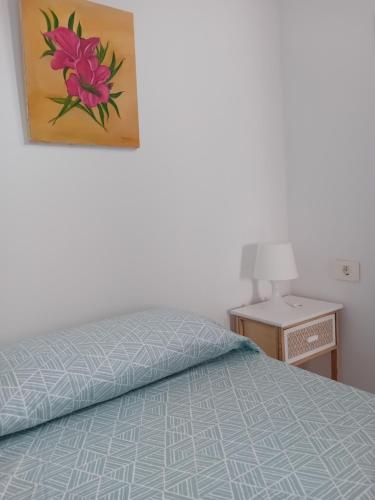 una camera da letto con un letto e un dipinto sul muro di El Rincon de Nina a La Laguna