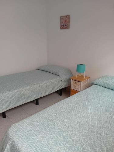 a room with two beds and a table with a night stand at El Rincon de Nina in La Laguna