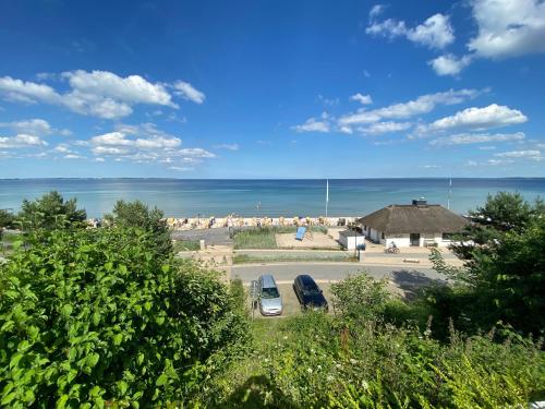 a view of a beach with two cars parked at Studio mit Panorama-Meerblick und direkter Strandlage in Scharbeutz in Scharbeutz