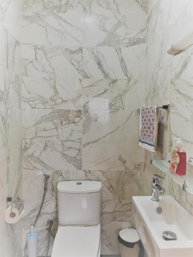 a bathroom with a white toilet and a sink at Les Residences de la Diaspora in Dakar