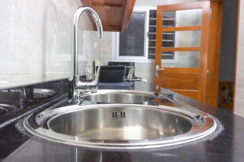 a stainless steel sink in a kitchen with a faucet at Les Residences de la Diaspora in Dakar