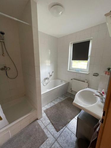a bathroom with a tub and a sink and a bath tub at Wohnung in Möser mit Grillmöglichkeit 