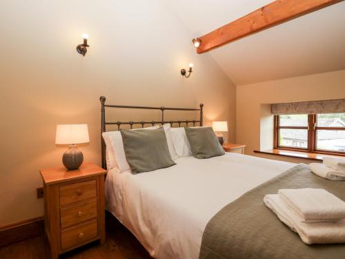 een slaapkamer met een groot bed en een raam bij Huntsmans Cottage in Ulverston