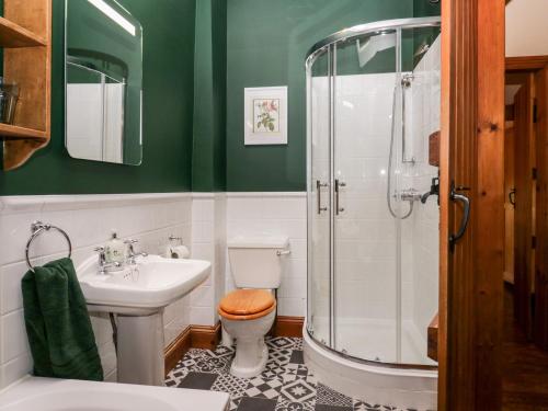 een badkamer met een wastafel en een douche bij Huntsmans Cottage in Ulverston
