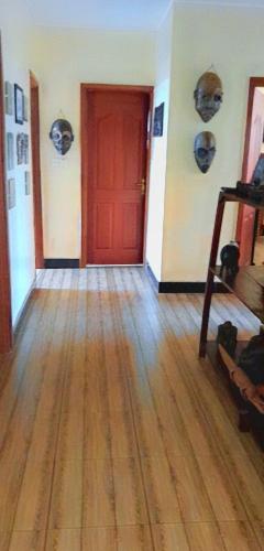 a room with a red door and a wooden floor at Phoebe Place 