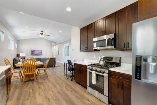 a kitchen with wooden cabinets and a dining room with a table at Modern Midtown Home Close to Downtown in Flagstaff