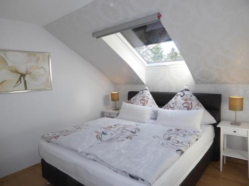 a bedroom with a white bed with a skylight at Ferienhaus zwischen den Seen in Sedlitz