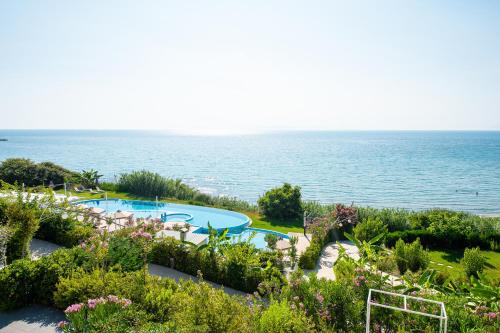 a view of a swimming pool and the ocean at Mare Dei Suites Hotel Ionian Resort in Skafidia