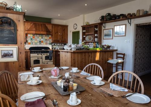 een keuken met een houten tafel met borden en kommen erop bij Britannia House in Lymington