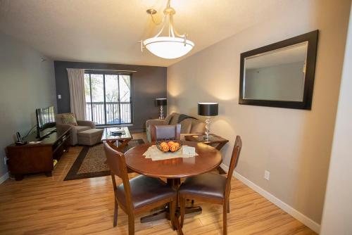 a living room with a wooden table and a dining room at Obasa Suites @ The Hallmark in Saskatoon