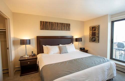 una camera con un grande letto e una finestra di Obasa Suites @ The Hallmark a Saskatoon