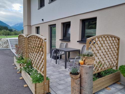 a patio with a table and chairs and some plants at Appartements Kumming - Urlaub inklusive Nationalparkcard in Rauris