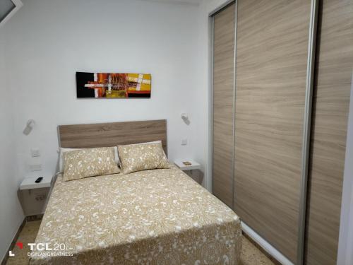 Dormitorio pequeño con cama y armario en Casa Maya, en Maspalomas