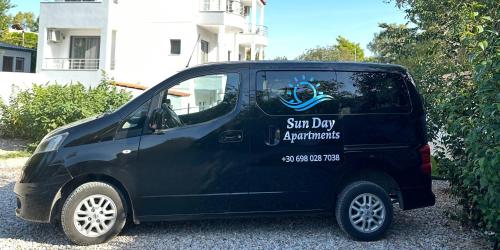 a black van parked in front of a house at Sun Day Apartments Free Airport Shuttle in Artemida