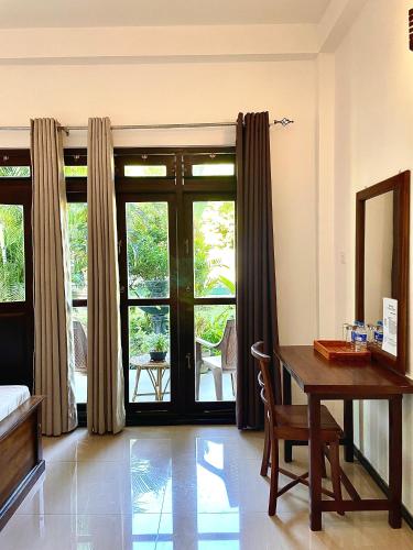 a room with a desk and a table and a window at Shan Star Weligama in Weligama