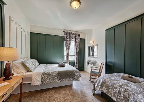 a bedroom with two beds and a table and a chair at Maison Zacharie in Desbiens
