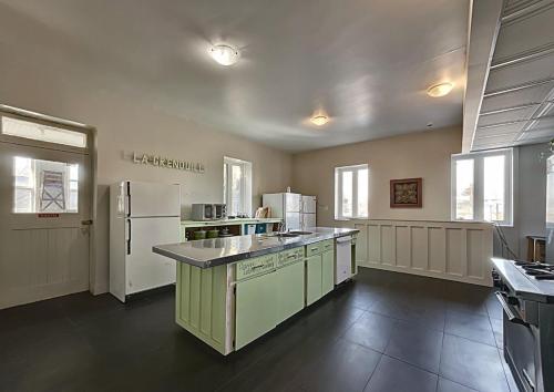 a large kitchen with white appliances in a room at Maison Zacharie in Desbiens