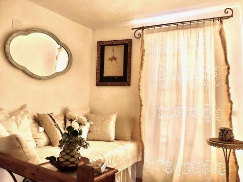 a bedroom with a bed and a mirror and a window at CASA DEL TEATRO Luxury Casas Vejer Debra in Vejer de la Frontera