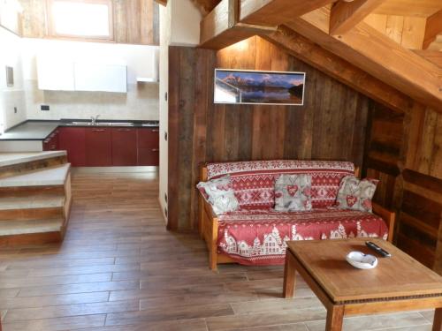 a living room with a couch and a table at Ampia mansarda con vista panoramica in La Salle