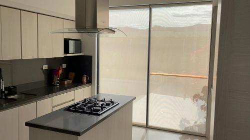 a kitchen with a stove and a window at La Veranera in Girardot