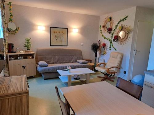 - un salon avec un canapé et une table dans l'établissement Charmant appartement dans résidence neuve - 5 places, à Nérac
