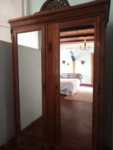 a mirror in front of a bedroom with a bed at Casona Patrimonial Cobquecura Hotel Boutique in Cobquecura