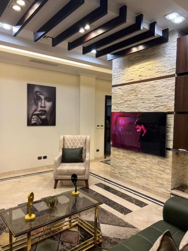 a living room with a chair and a fireplace at Villa in Allegria El Sheikh Zayed in Sheikh Zayed