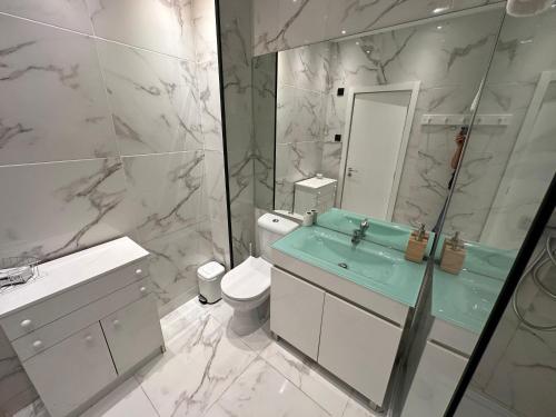 a bathroom with a sink and a toilet and a mirror at Porto Foz Beach in Porto