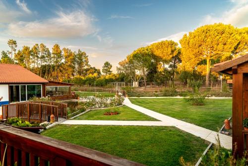 a garden with a fence and a yard with green grass at Quinta do Cutato - Piscina Guest House in Santo Estêvão