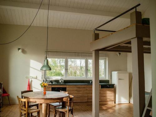 d'une cuisine et d'une salle à manger avec une table et une mezzanine. dans l'établissement Le Domaine du Meunier, à Mortagne-sur-Gironde