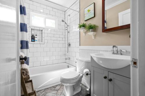 Baño blanco con lavabo y aseo en Madison Terrace - Large Home With Game Room - 10, en Clarksville
