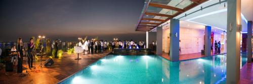 a group of people standing around a pool in a building at Hotel Parami in Yangon