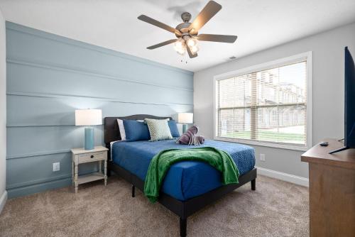 1 dormitorio azul con 1 cama y ventilador de techo en Modern 3-bedroom Close To Ft, Campbell, en Clarksville