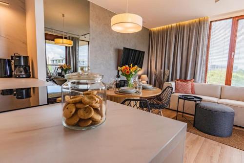 a kitchen and living room with a table with cookies in a jar at Apartament na Grabiszyńskiej in Wrocław