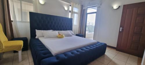 - une chambre dotée d'un lit bleu avec un ours en peluche dans l'établissement Pearl Beach Lifestyle, à Mombasa