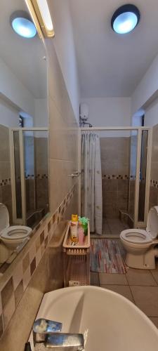 La salle de bains est pourvue de 2 toilettes et d'une baignoire. dans l'établissement Pearl Beach Lifestyle, à Mombasa
