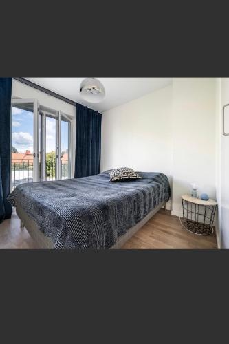ein Schlafzimmer mit einem Bett und einem großen Fenster in der Unterkunft Central apartment 5min drive to the Airport. in Stockholm