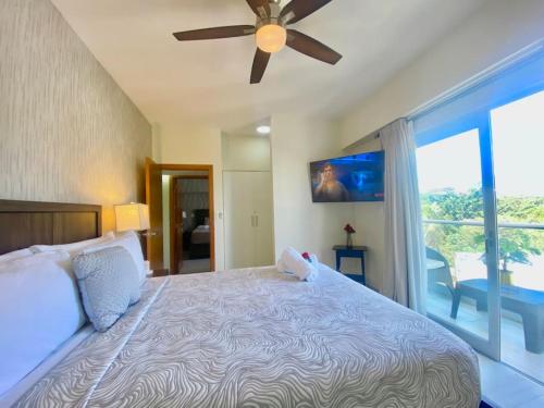 Schlafzimmer mit einem großen Bett und einem Deckenventilator in der Unterkunft Cozy City Center Condo Pool in Los Prados