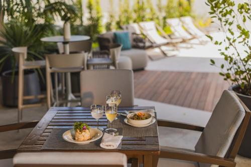 a wooden table with plates of food and glasses of wine at Hotel Marina Atlântico in Ponta Delgada