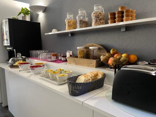 - un comptoir de cuisine avec des bols de nourriture dans l'établissement Hôtel Le Lacuzon, à Moirans-en-Montagne